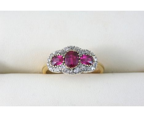 A RUBY AND DIAMOND TRIPLE CLUSTER RING set with three oval-shaped rubies within a surround of single-cut diamonds, in 18ct. g