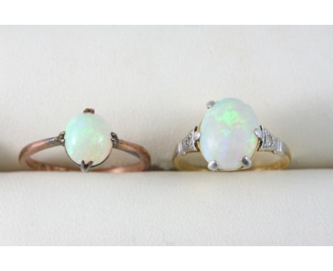 AN OPAL AND DIAMOND RING the oval cabochon opal is set with a diamond to each shoulder, in 18ct. gold, size J, together with 