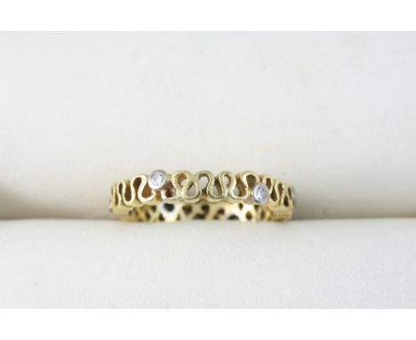 A GOLD RING of open work design, set with small diamonds. Size N.