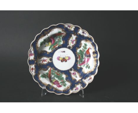 18THC WORCESTER PLATE with a shaped rim and painted with exotic fancy birds and insects within gilt scroll cartouches, on a b