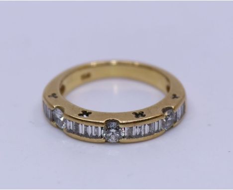 An 18ct. yellow gold and diamond half eternity ring, flush set three round brilliant cut diamonds with channel set baguette c