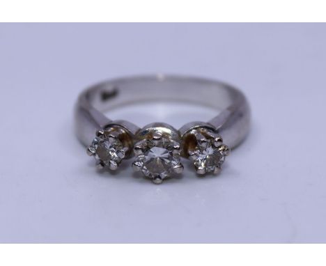 An 18ct. white gold three stone diamond ring,&nbsp;claw set three graduated round brilliant cut diamonds (estimated total dia