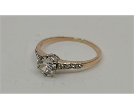 A precious yellow metal and diamond ring, set central round brilliant cut diamond with graduated rose cut diamonds to shoulde
