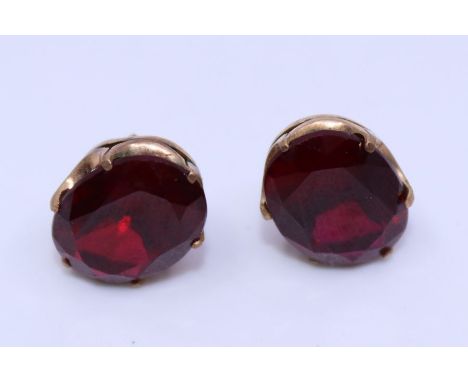 A pair of precious yellow metal and synthetic ruby earrings,&nbsp;each claw set oval mixed cut synthetic ruby, (yellow metal 