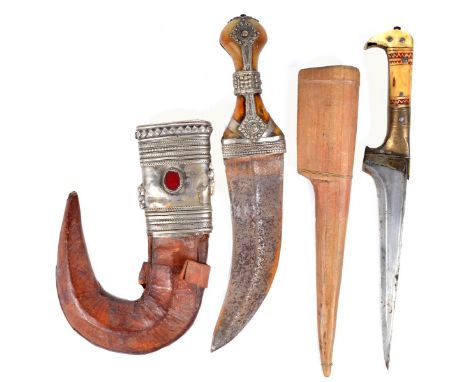 An Arabian dagger (jambiya), broad curved blade 7.25 in., waisted horn hilt overlaid with beaded white metal bands, scabbard 