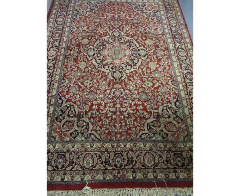 A late 20th century red ground, multi guard border carpet, 97 x 64