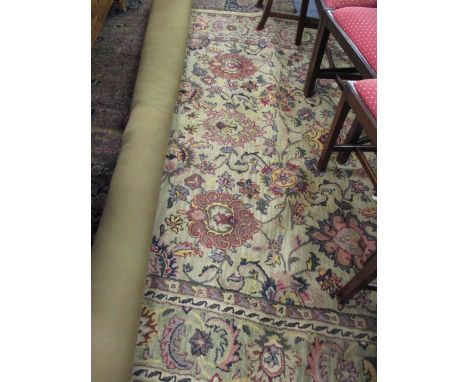 An Indian woollen carpet with a green ground and floral designs