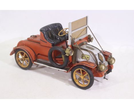 An orange tinplate vintage Renault 1950s model vehicle. Part of the left side sill has broken off. There are various scuff ma