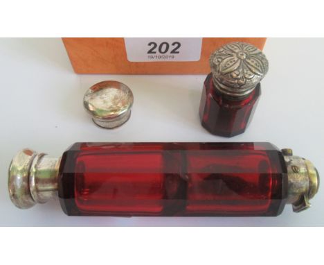 Two ruby glass perfume bottles.  Condition Report: Large bottle has broken top.  Overall length 13cms.  Small bottle, minor d