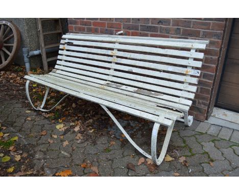 A wrought iron and white painted slatted garden bench.