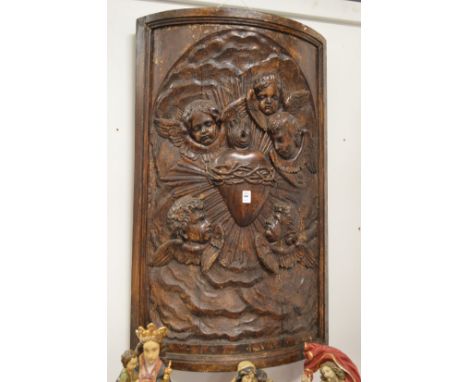 A good large bow fronted carved wooden plaque depicting cherubs.