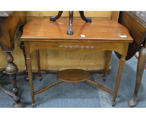 An Edwardian mahogany fold-over card table.