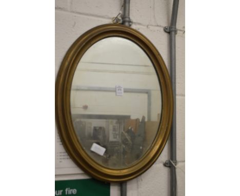 A brass framed oval mirror.