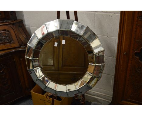 A decorative modern Venetian style circular segmented wall mirror.