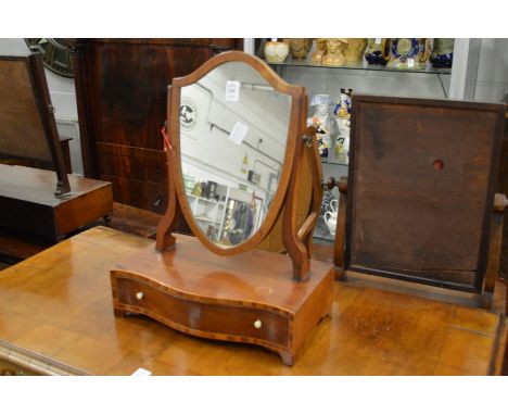 A small mahogany shield shape toilet mirror with serpentine fronted base.