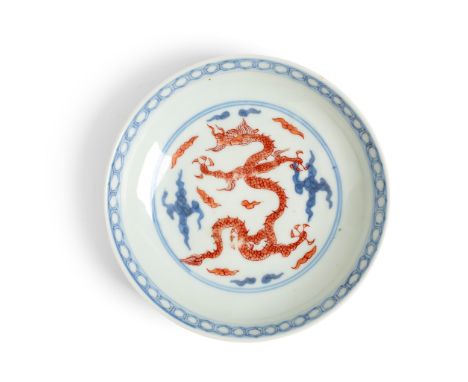 IRON-RED DECORATED BLUE AND WHITE 'DRAGON' DISH YONGZHENG MARK raised on a short straight foot to a rounded shallow body and 