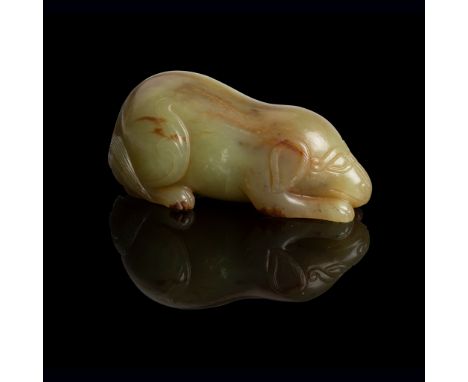 YELLOWISH CELADON JADE CARVING OF A DOG QING DYNASTY, 18TH-19TH CENTURY carved in round as a recumbent dog with its head tuck