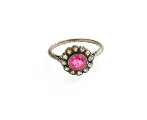 A Synthetic Ruby and Diamond Cluster Ring, the round cut synthetic ruby within a border of rose cut diamonds, in white milleg
