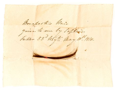 A lock of Napoleon’s hair, in a folded slip of paper with contemporary ink note “Bonaparte’s hair given to me by Captain Full