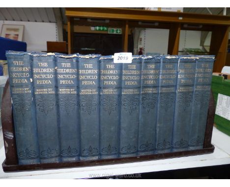 A book trough containing The Children's Encyclopedia, edited by Arthur May.