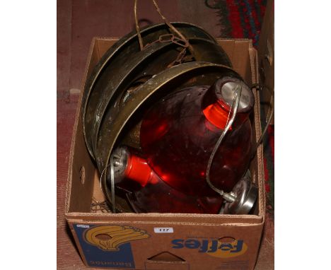 A box of three brass industrial light shades, two enamel Coolicon shades and two red glass examples.