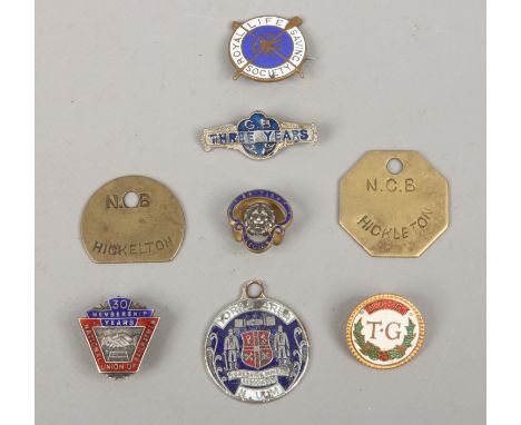 A collection of enamel badges and miners check tags.
