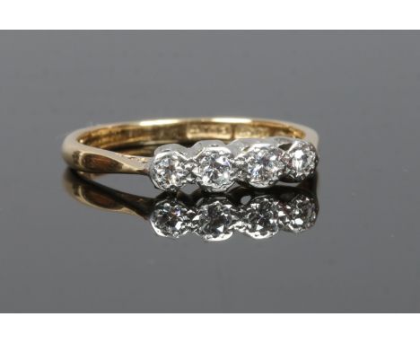 An early 20th century gold and platinum four stone diamond ring, size M.