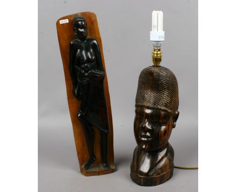 A carved tribal hardwood bust lamp along with a similar carving.