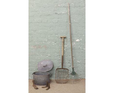 A collection of metalwares and land tools; galvanized bucket and cover, iron shoe lasts, rake, potato shovel etc.