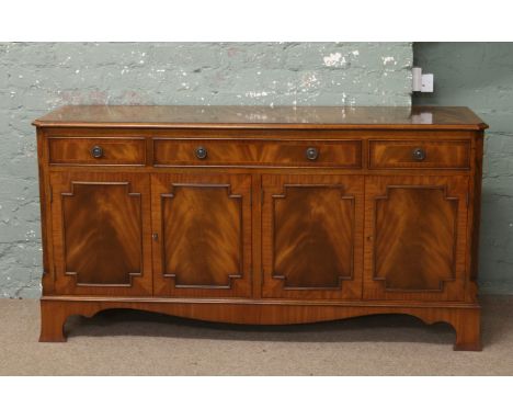 A flame mahogany sideboard crossbanded and raised on bracket feet.