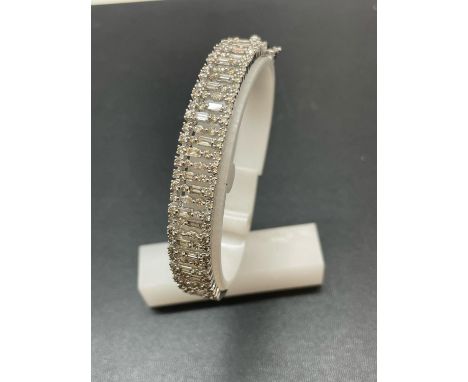 A NEW 9 CARAT WHITE GOLD HINGED BANGLE, SET WITH BRILLIANT AND BAGUETTE CUT DIAMONDS OF TOTAL WEIGHT 3.75 CARAT GOLD WEIGHT 2