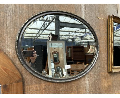 AN OVAL GILT FRAMED BEVEL EDGE MIRROR 