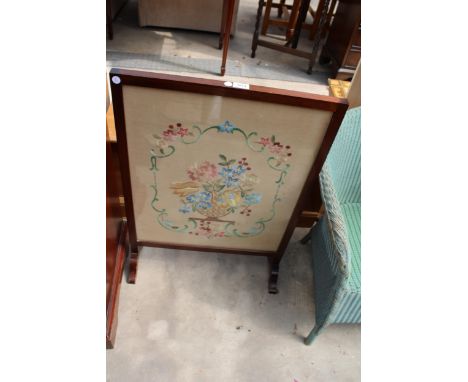 AN EDWARDIAN MAHOGANY FIRESCREEN WITH FLORAL SILKWORK DECORATION 