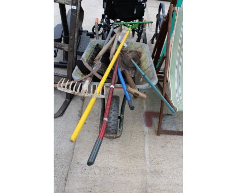 A METAL WHEEL BARROW AND AN ASSORTMENT OF GARDEN TOOLS TO INCLUDE RAKES AND SCYTHES ETC 
