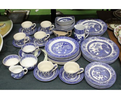 A QUANTITY OF BLUE AND WHITE WILLOW PATTERN DINNERWARE TO INCLUDE VARIOUS SIZES OF PLATES, BOWLS, JUGS, CUPS, SAUCERS AND SUG