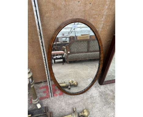 AN OVAL MAHOGANY MIRROR 