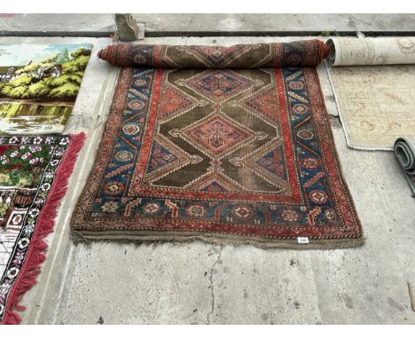 A VINTAGE RED PATTERNED FRINGED RUG 