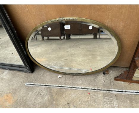 AN OVAL BRASS FRAMED MIRROR 