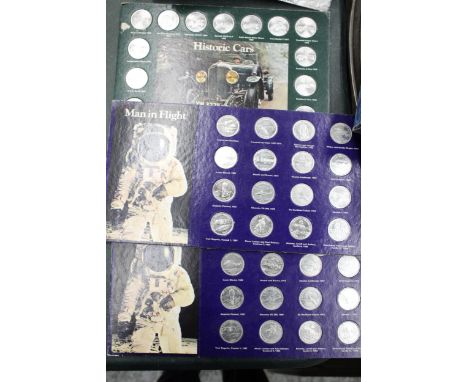 THREE SETS OF SHELL COLLECTABLE COINS ON CARDS, TO INCLUDE MAN'S FIRST FLIGHT X 2 AND HISTORIC CARS 
