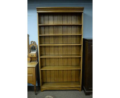 A 20th Century light oak open bookcase with adjustable shelving and panelled back (formerly fitted or part of a larger piece)