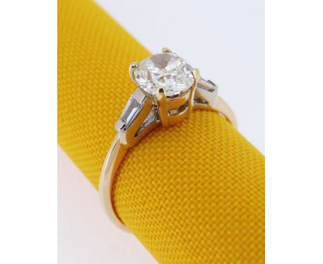 18CT GOLD DIAMOND RING, the central stone (0.7cts approx.) flanked by diamond tapering baguette shoulders, ring size K, 2.4gm