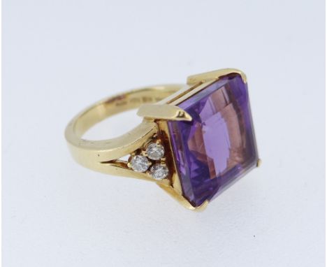 18CT GOLD AMETHYST &amp; DIAMOND DRESS RING, the large square cut amethyst (12 x 12mms) flanked by a trio of diamonds to each