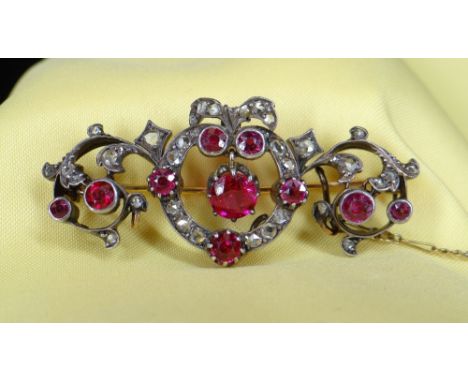 YELLOW &amp; WHITE METAL SET DIAMOND &amp; RUBY BAR BROOCH of naturalistic bow, scroll and leaf design, 11.3gms Provenance: p