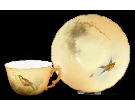 A ROYAL WORCESTER TEACUP AND SAUCER, PAINTED WITH BIRDS AND RAISED GILT FOLIAGE, ON A SHADED APRICOT GROUND, FEATHER MOULDED 