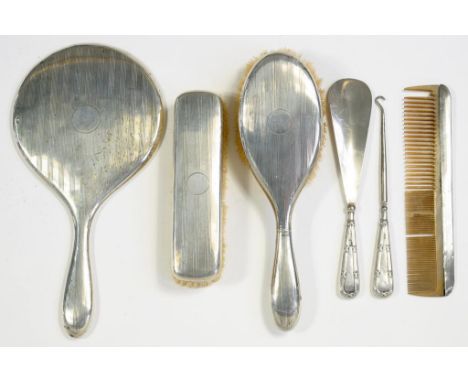 A GEORGE V FOUR PIECE SILVER BRUSH SET, BIRMINGHAM 1927 AND A SILVER HANDLED SHOE HORN AND BUTTON HOOK