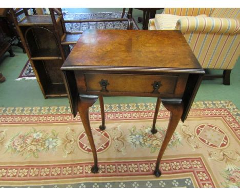 A Georgian style burr walnut lamp table, the rising leaves over a single frieze drawer on cabriole legs 