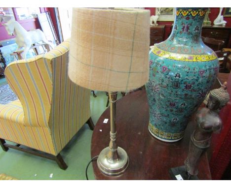 A silver coloured table lamp with pink tartan shade