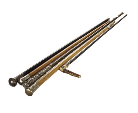 A collection of five walking canes and sticks, including a fine Indian white metal mounted tall cane on bamboo shaft, two fur