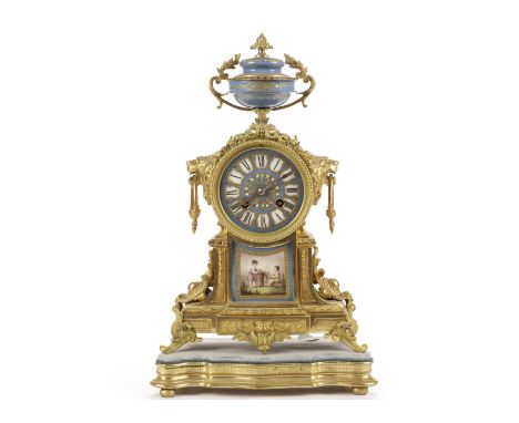 A 19th century French Louis XVI style gilt mantel clock, the neoclassical gilt body with a pair of lion head and loop handles