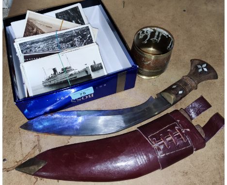 A selection of vintage postcards and a kukri 